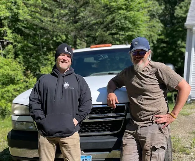 Steve Quilliam of Mess Haul Men standing with a member of the crew beside a white pickup