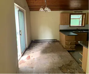 Kitchen and dining area after an estate clean-out, floor clear under the pendant light